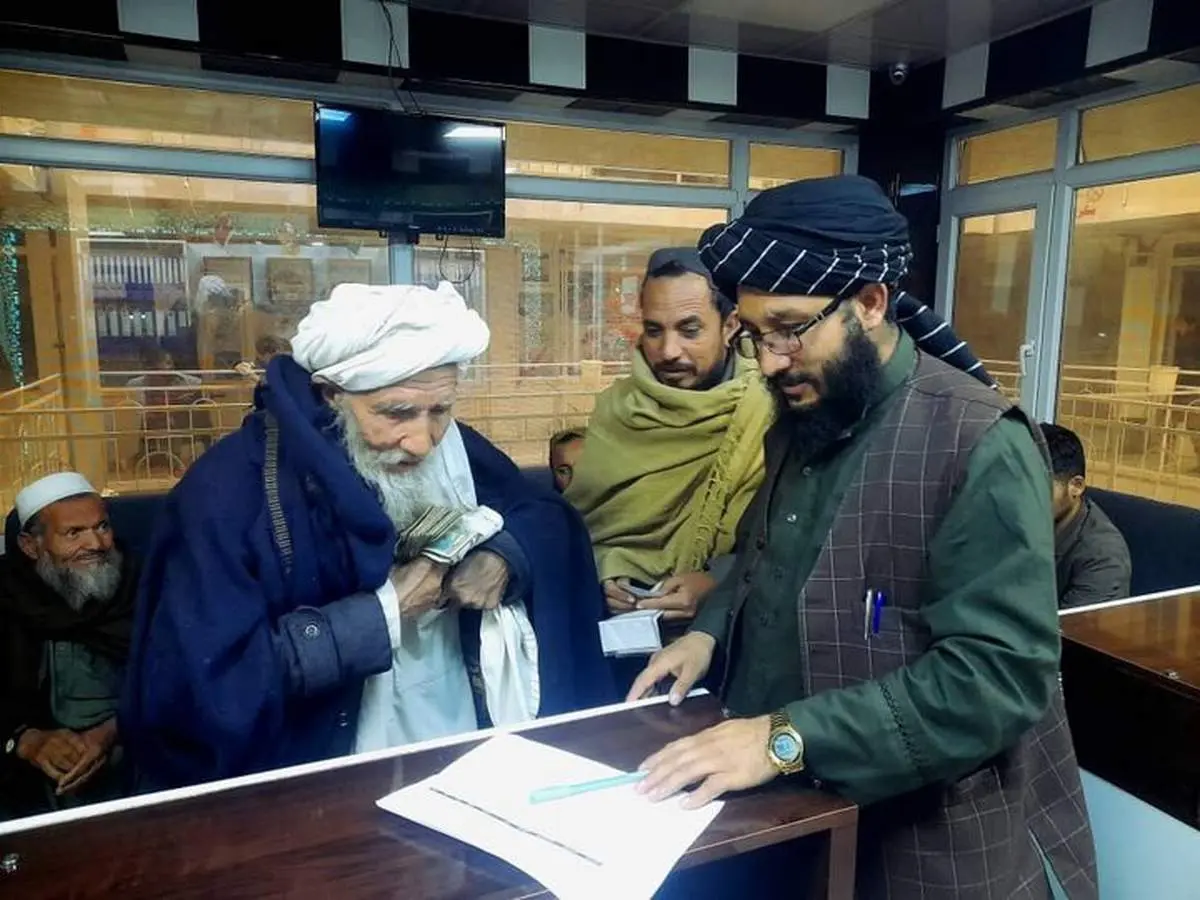 تصاویری از توزیع پول و غذا بین مهاجران افغان توسط طالبان